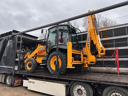 Ein Baggerlader ist auf den LKW verladen