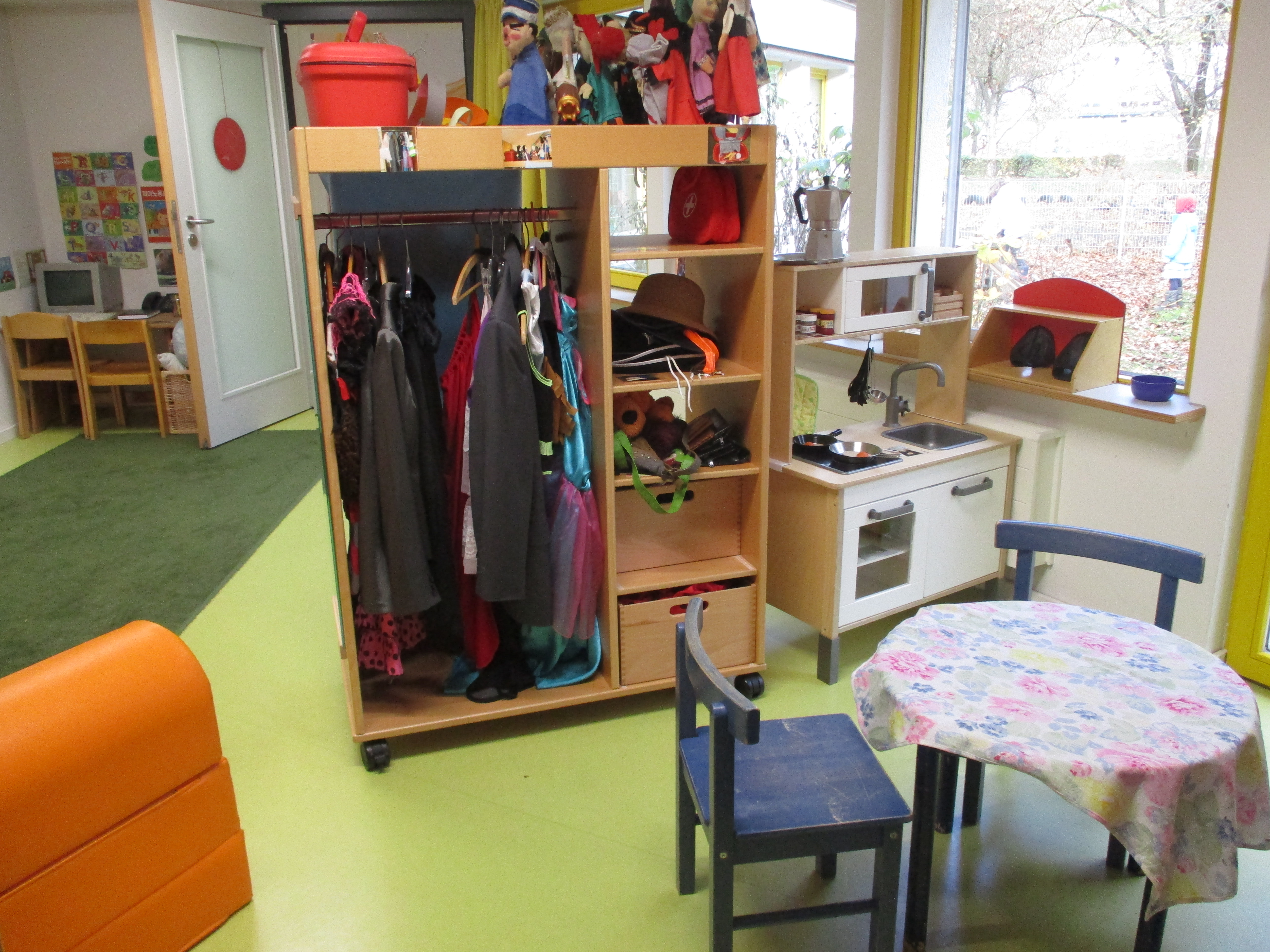 Das Bild zeigt den Rollenspielbereich im Kinderhaus Feuerhägle. Es ist eine Kinderküche, Verkleidungen und ein kleiner runder Tisch zu erkennen.