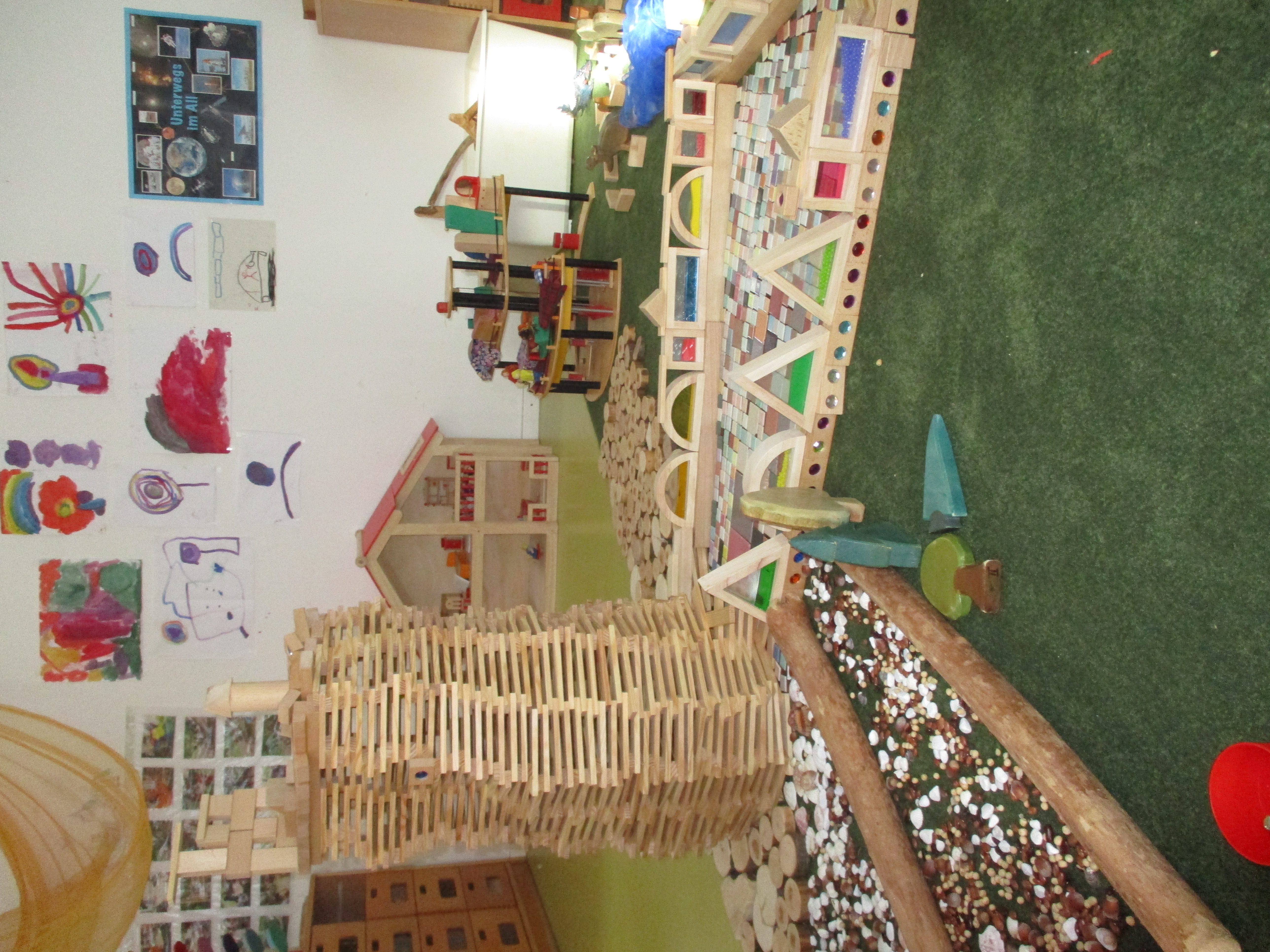 Das Bild zeigt den Baubereich. Es ist ein Turm aus Holzstäben, Mosaiksteinchen und Holzscheiben erkennbar.