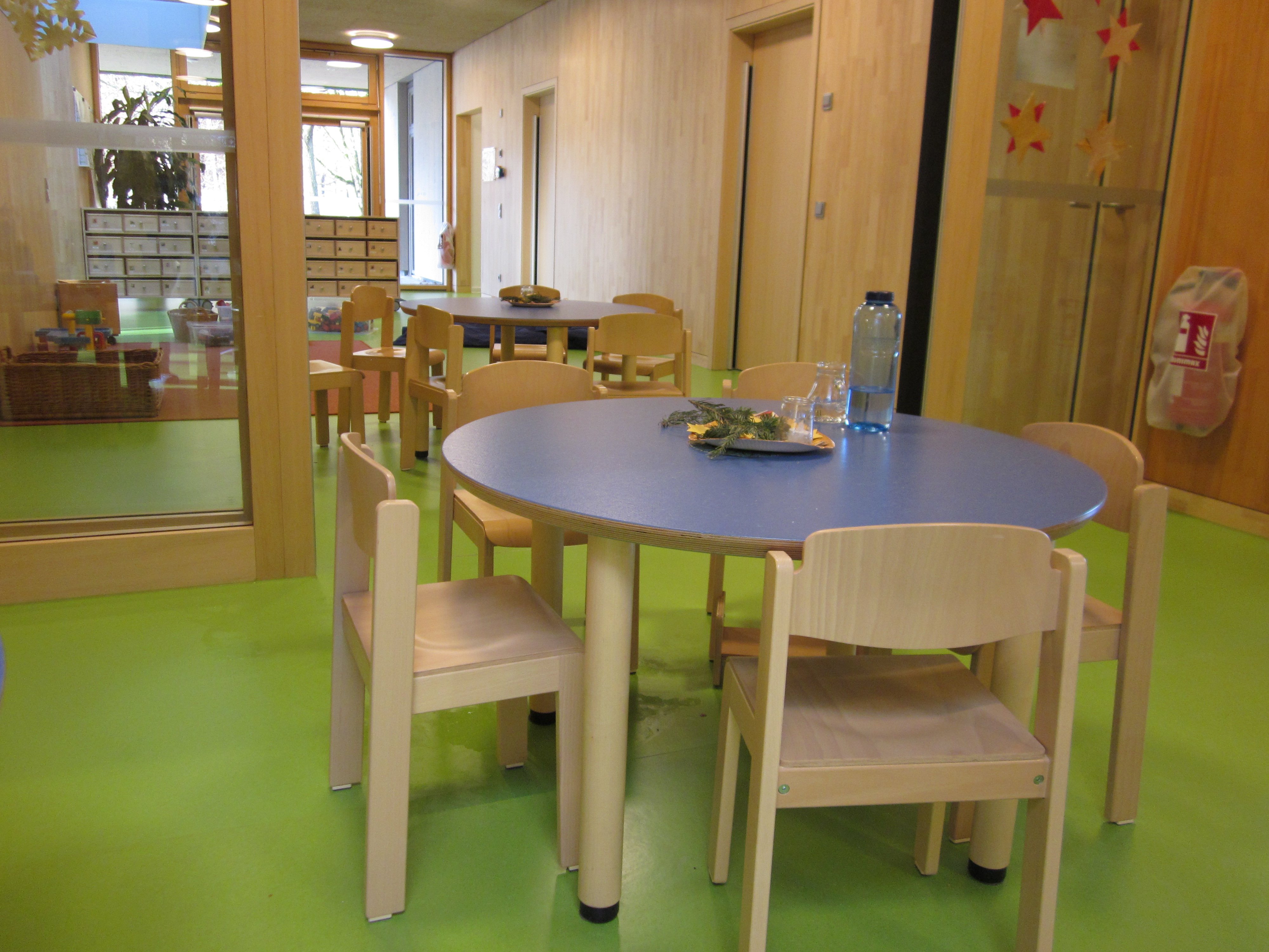 Hier ist der Essbereich zu sehen. Die Tische sind rund mit jeweils fünf Stühlen.