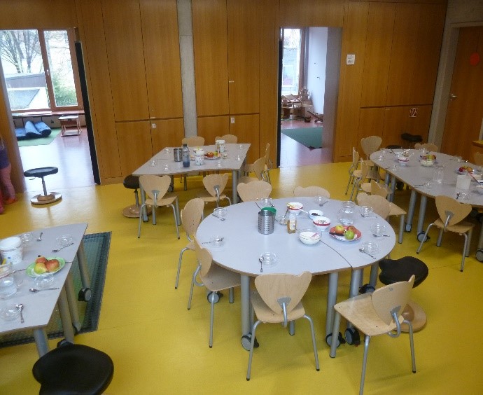 Auf dem Bild ist der Essbereich des Kinderhaus Hirschau zu sehen. Die Tische sind für das Frühstück gedeckt.