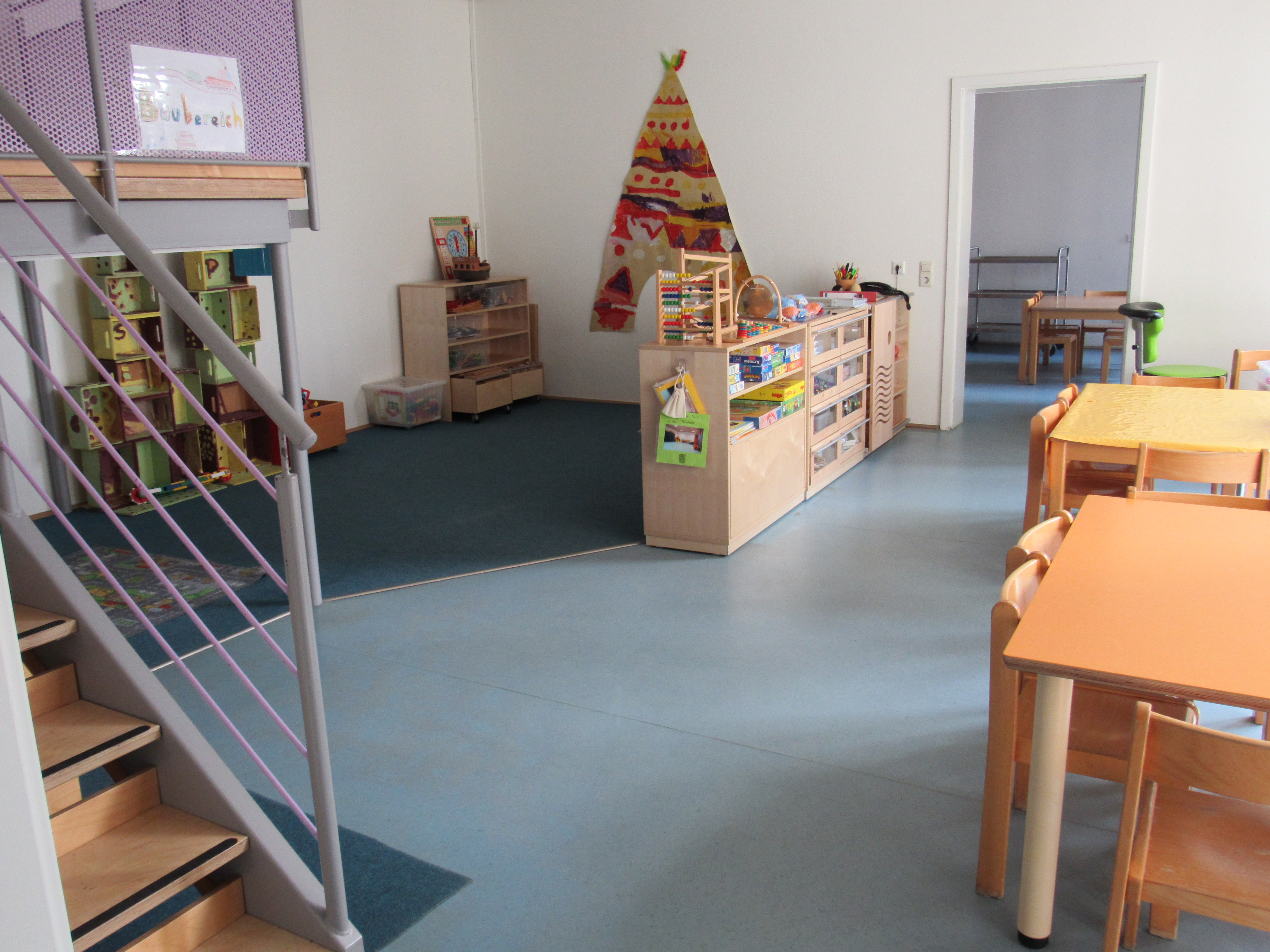 Das Bild zeigt das Bauzimmer des Kinderhaus Hauptstraße. Es sind verschiedene Spielsachen, Regale und Tische zu sehen.