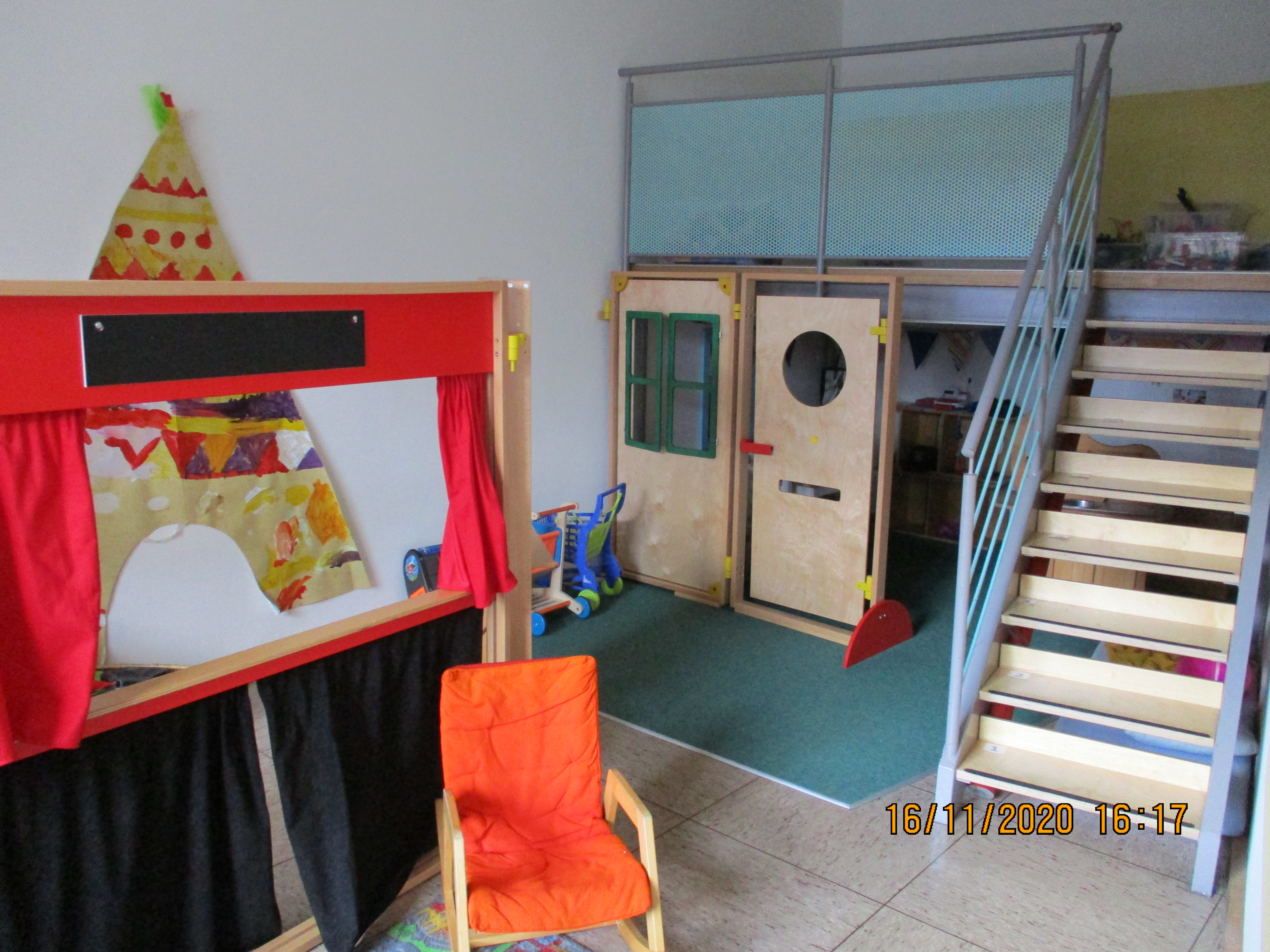 Es ist ein Puppentheater erkennbar. Unterhalb einer Treppe ist eine Kinderküche zu sehen.
