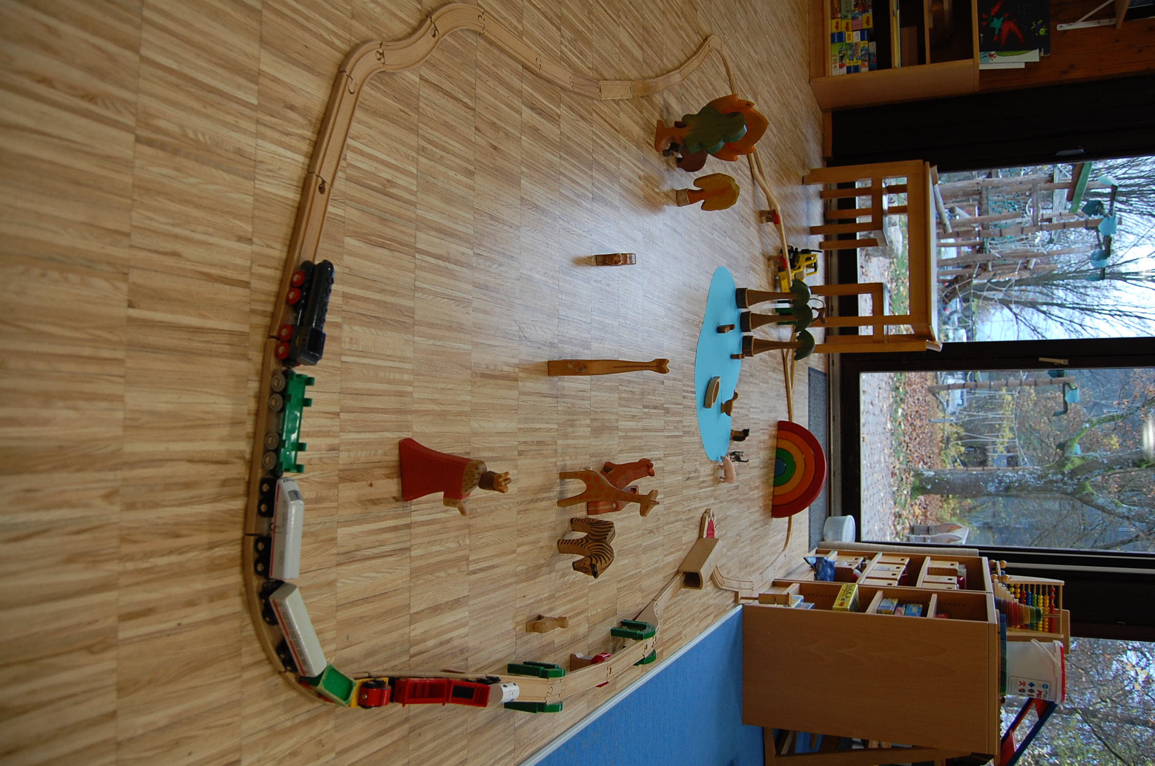 Holzeisenbahn und Figuren auf dem Boden