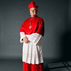 aus der Serie „Kleider machen Leute“

Porträt von Gerhard Ludwig Müller, Bischof, Deutschland, 2012, in Dienstkleidung

„Als ich zum ersten Mal das Priestergewand trug, war ich am Ziel meiner Wünsche angekommen. Am Anfang war ich noch ein bisschen ungelenk in der Soutane, weil man es nicht gewohnt ist, in so langen Kleidern zu gehen, das müssen wir als „Hosenträger“ erst lernen. Auch musste ich mich erst daran gewöhnen, dass mich die Menschen im Bischofskleid nicht als Privatperson sehen, sondern als Priester. Die Priesterkleidung mit entsprechendem Kragen ist wichtig, weil sich darin eine Lebensentscheidung zeigt. In ihr habe ich bewusst mehr Haltung und einen aufrechten Gang.“