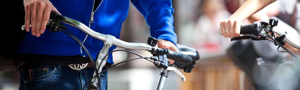Zwei Personen mit Fahrradlenkrädern in den Händen