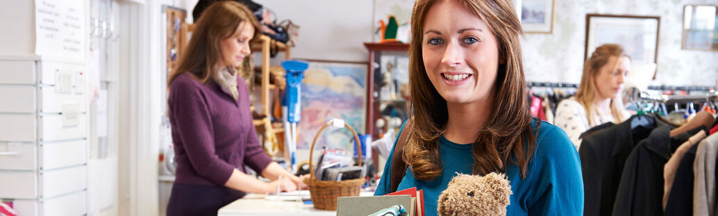 Frau mit Teddy in einem Laden mit Gebrauchtwaren