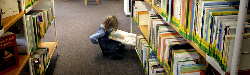 Ein Kind liest in der Stadtbücherei