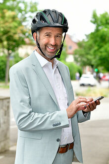 Boris Palmer mit Fahrradhelm und Handy in der Hand